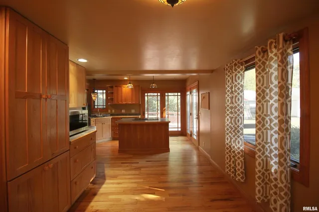 a kitchen with stainless steel appliances granite countertop a refrigerator a sink and a stove with wooden floor