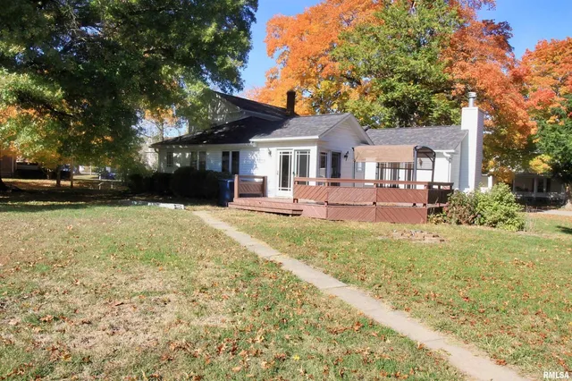 a front view of a house with a yard and trees