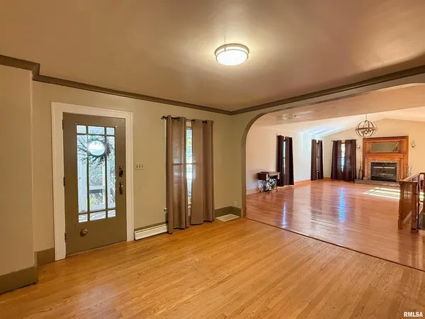 a view of a hallway with wooden floor and livingroom