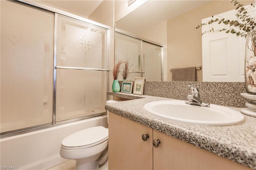 1230 Reserve Way, Unit 302 Naples, FL 34105 - Photo 12 of 28 a bathroom with a granite countertop sink toilet and shower