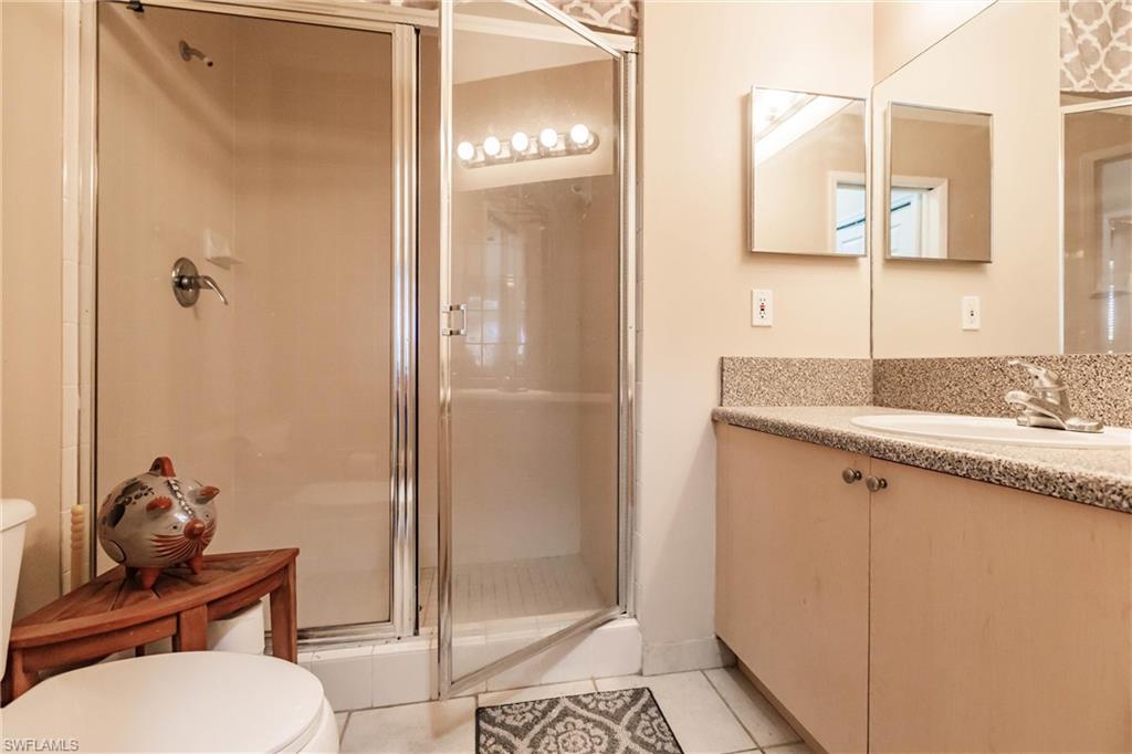 1230 Reserve Way, Unit 302 Naples, FL 34105 - Photo 14 of 28 a bathroom with a granite countertop sink and a mirror