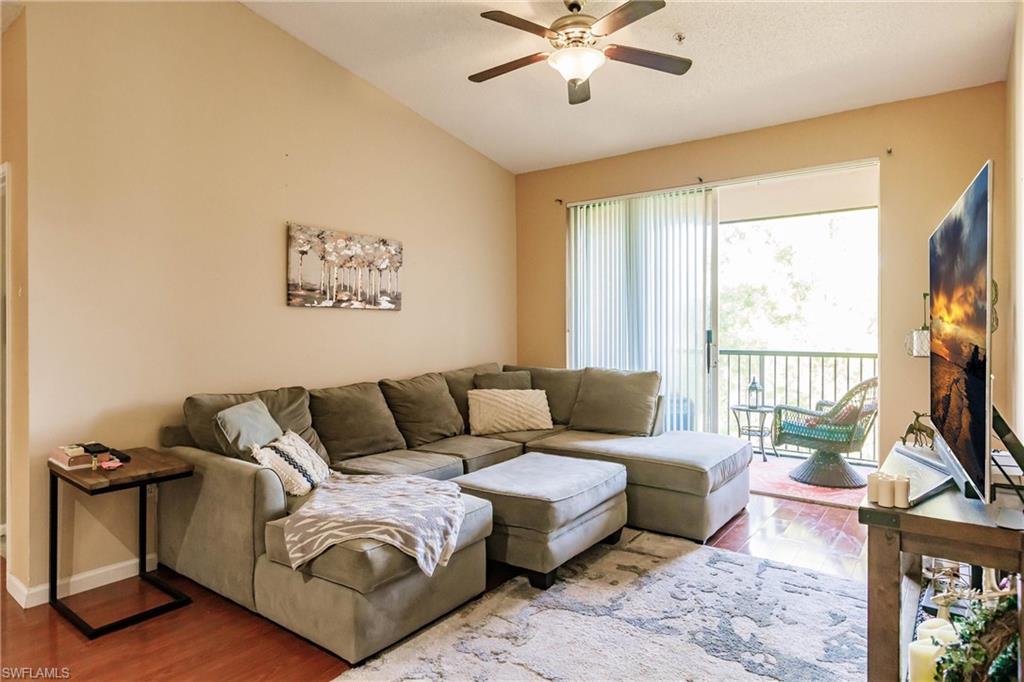 1230 Reserve Way, Unit 302 Naples, FL 34105 - Photo 4 of 28 a living room with furniture a flat screen tv and a large window