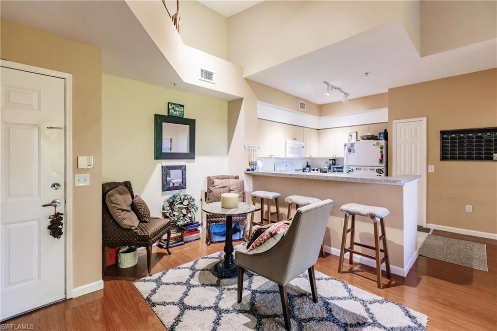 1230 Reserve Way, Unit 302 Naples, FL 34105 - Photo 6 of 28 a dining room with furniture and wooden floor