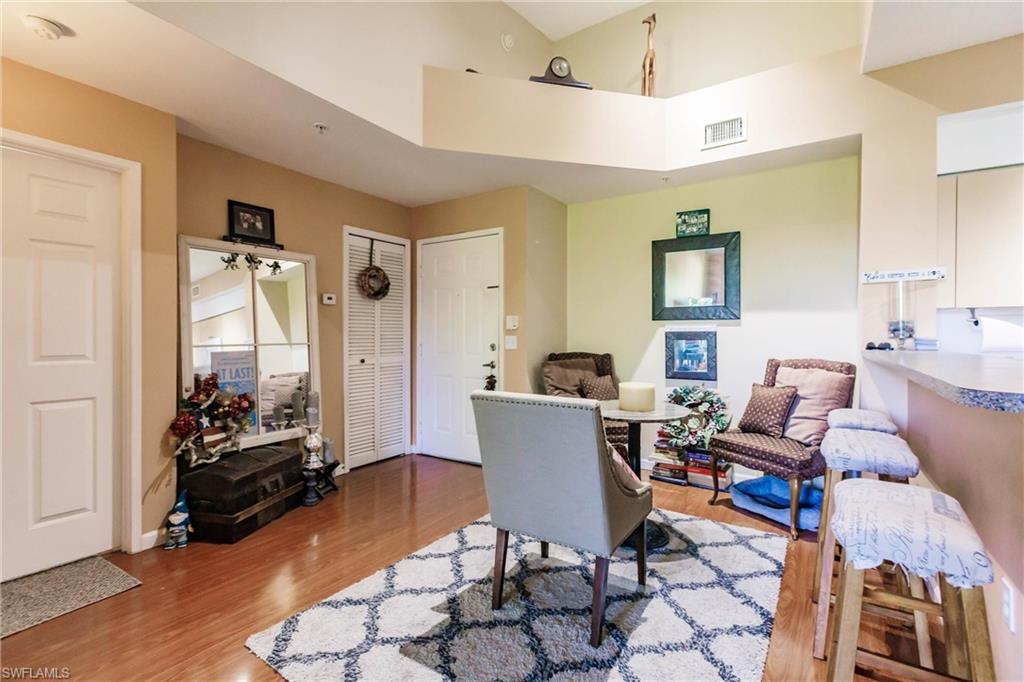 1230 Reserve Way, Unit 302 Naples, FL 34105 - Photo 7 of 28 a living room with furniture and wooden floor