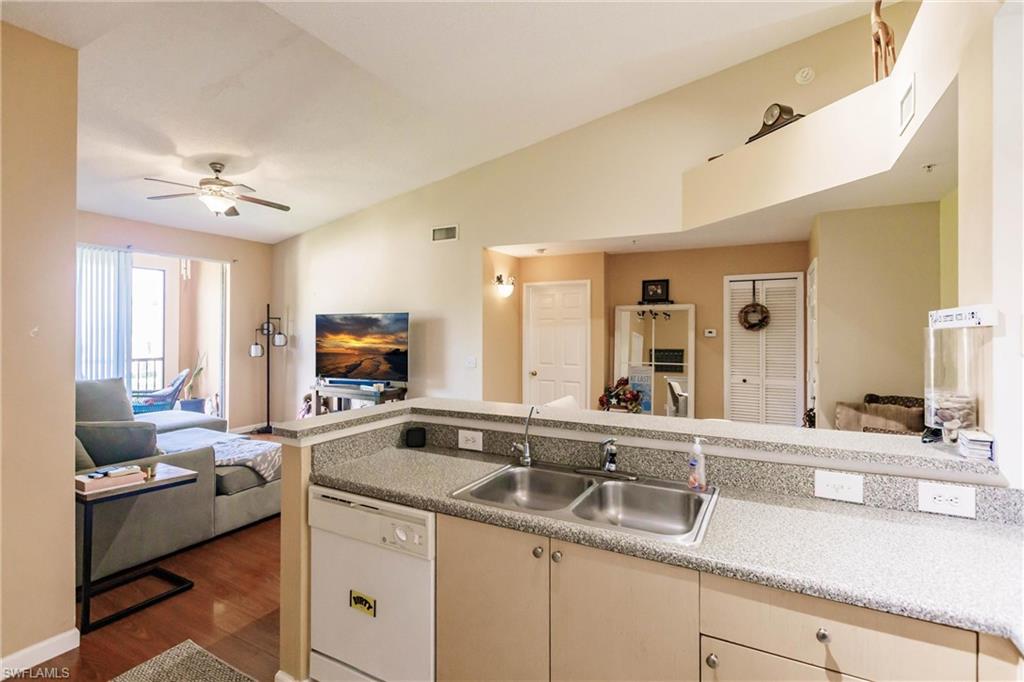 1230 Reserve Way, Unit 302 Naples, FL 34105 - Photo 10 of 28 a living room with furniture and a fireplace