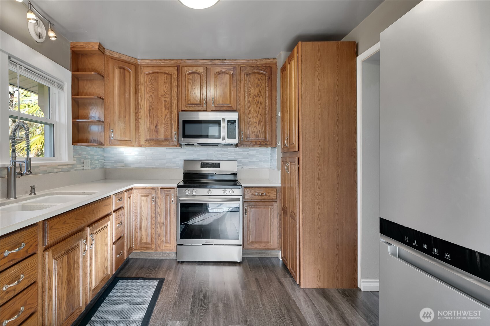 1547 Southwest Myrtle Street Seattle, WA 98106 - Photo 9 of 40 a kitchen with stainless steel appliances a sink cabinets and a wooden floor