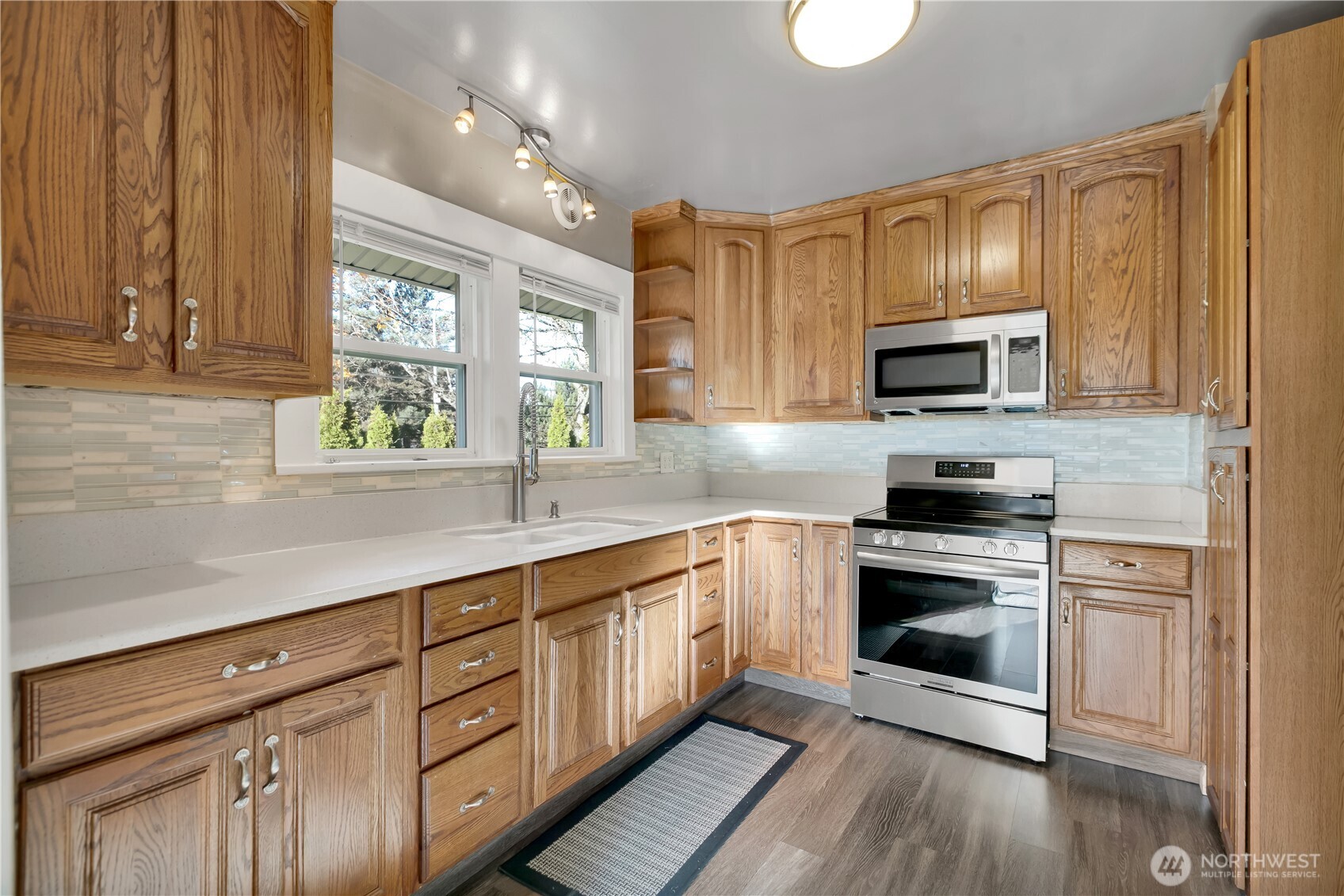 1547 Southwest Myrtle Street Seattle, WA 98106 - Photo 10 of 40 a kitchen with kitchen island granite countertop a sink cabinets stainless steel appliances and a window