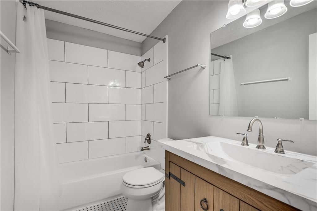 1214 Wynnes Ridge Circle Southeast Marietta, GA 30067 - Photo 18 of 24 a bathroom with a granite countertop sink a toilet and shower