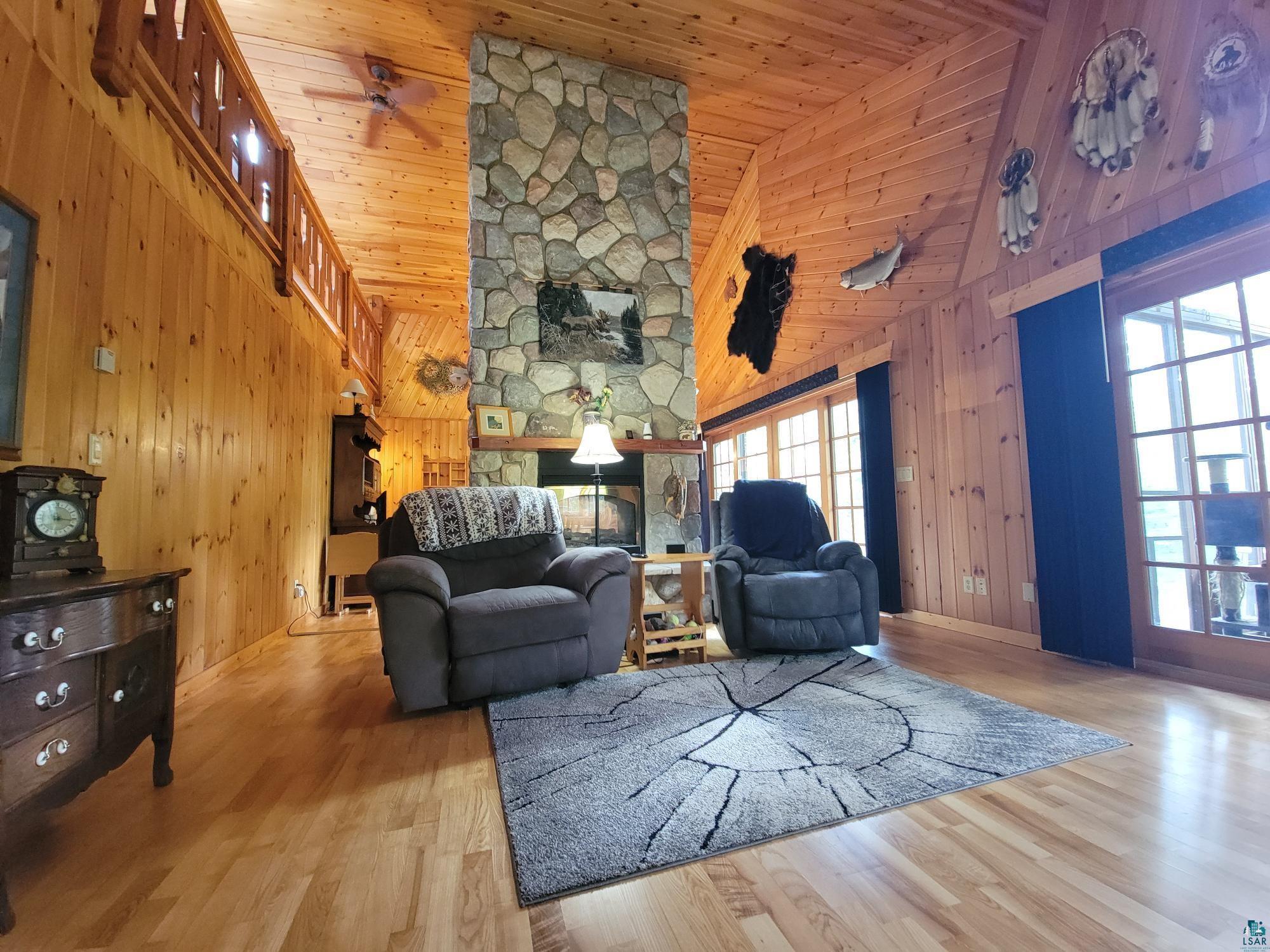 181 Linnell Road Grand Marais, MN 55604 - Photo 27 of 77 Vaulted wood-paneled ceilings, stone-faced fireplace, wood-finish flooring, and a second-story interior balcony