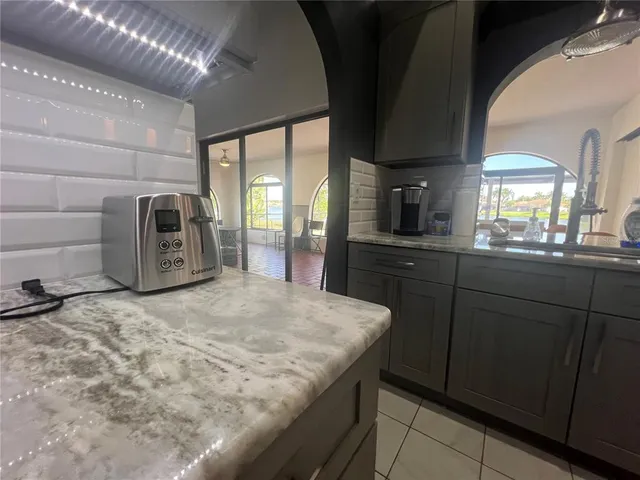 a kitchen with granite countertop a stove a sink and a refrigerator
