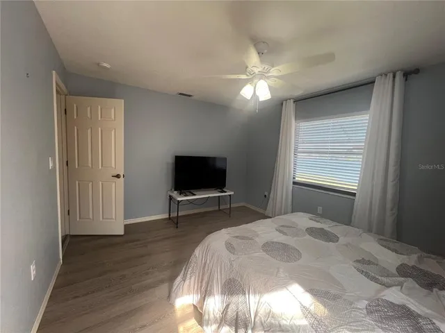 a spacious bedroom with a large bed and a chandelier