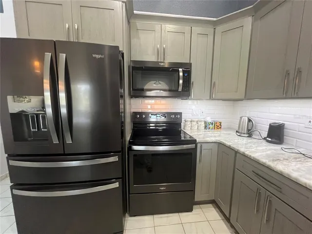 a metallic refrigerator freezer sitting in a kitchen