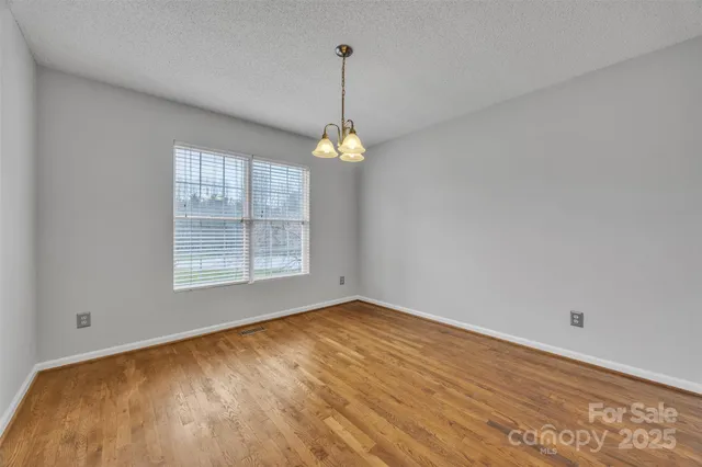 a view of a room with wooden floor and a ceiling fan