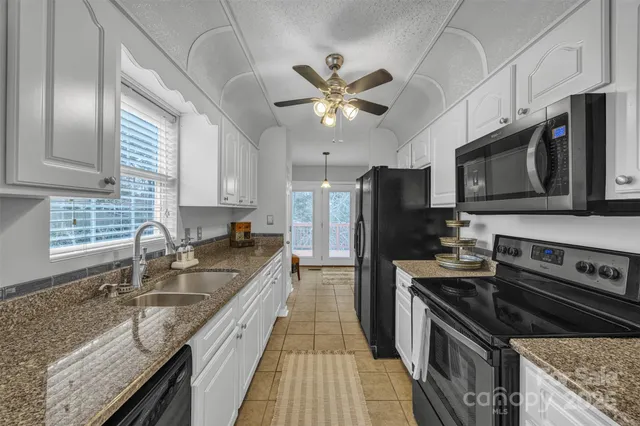 a kitchen with a sink dishwasher a refrigerator and cabinets