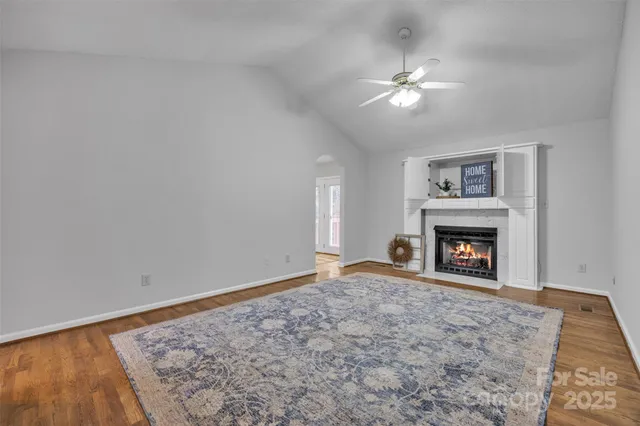 a view of a livingroom with a fireplace and chandelier fan