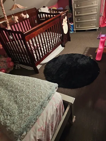 a bed sitting in a bedroom next to a cabinet