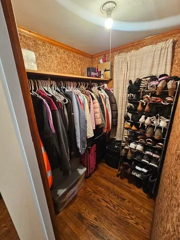 a view of walk in closet with clothes and shoes