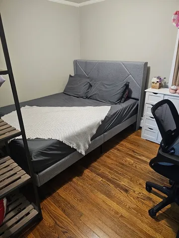 a bedroom with bed and wooden floor