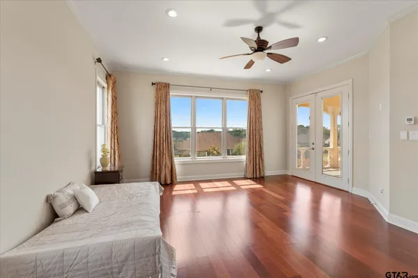 a living room with wooden floor and a ceiling fan