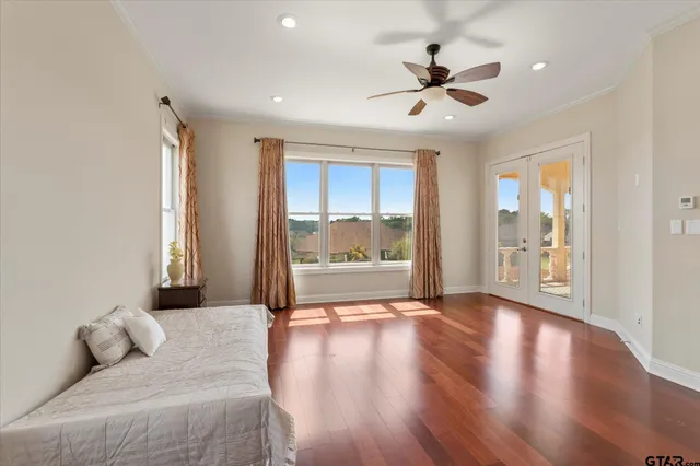 a living room with wooden floor and a ceiling fan
