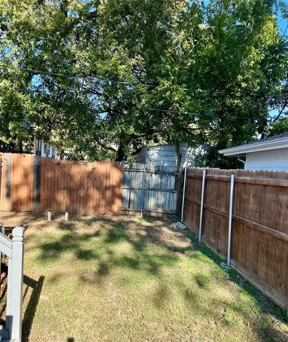 a backyard with wooden fence and trees