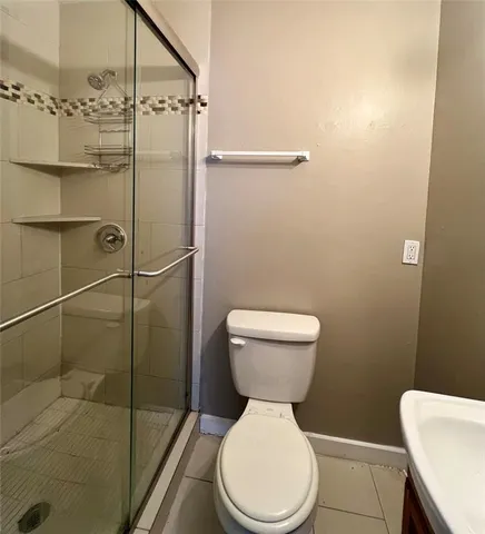 a white toilet sitting next to a shower