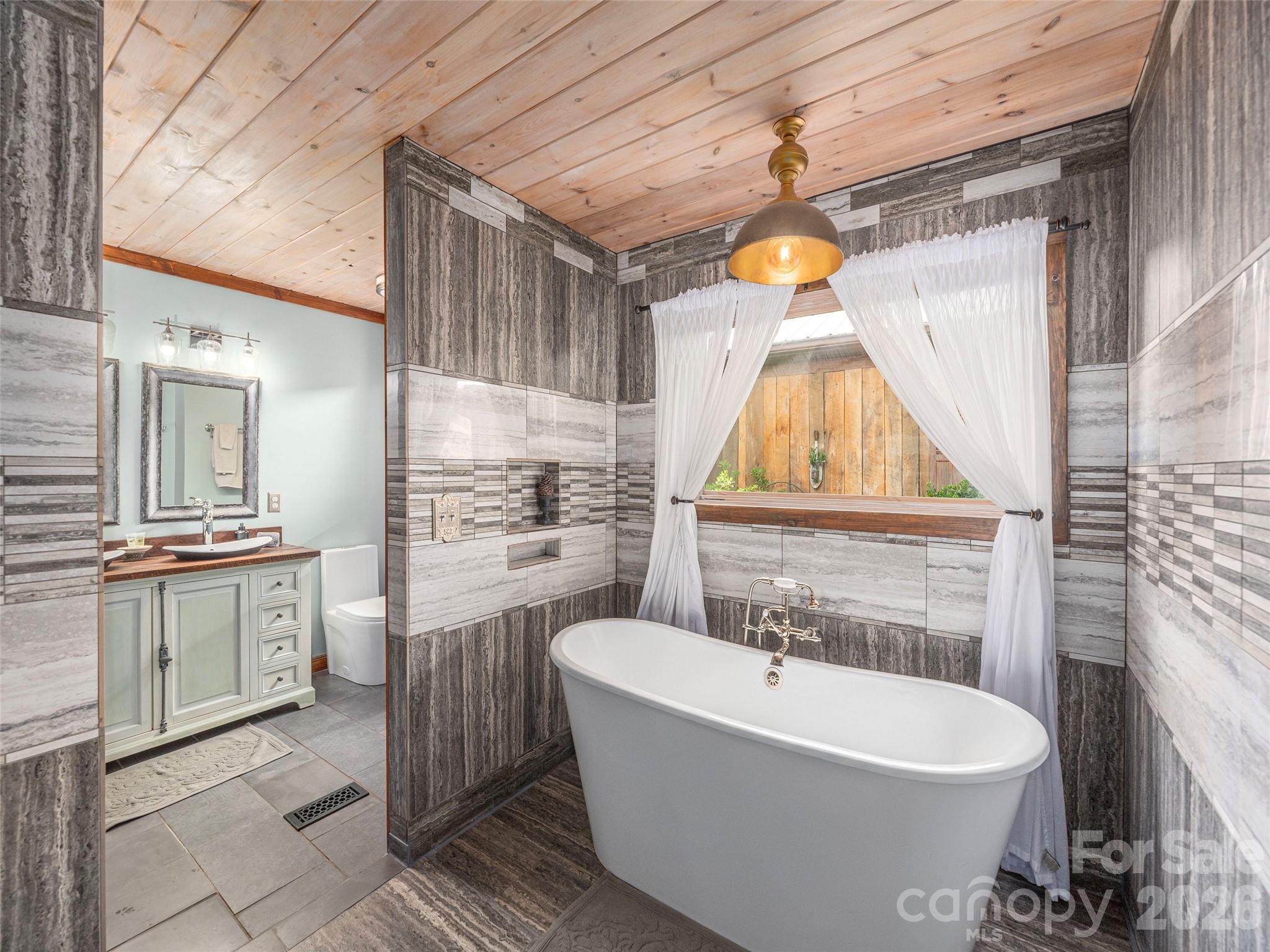 461 Ferguson Cove Loop Clyde, NC 28721 - Photo 23 of 46 a bathroom with a sink a bathtub and a window