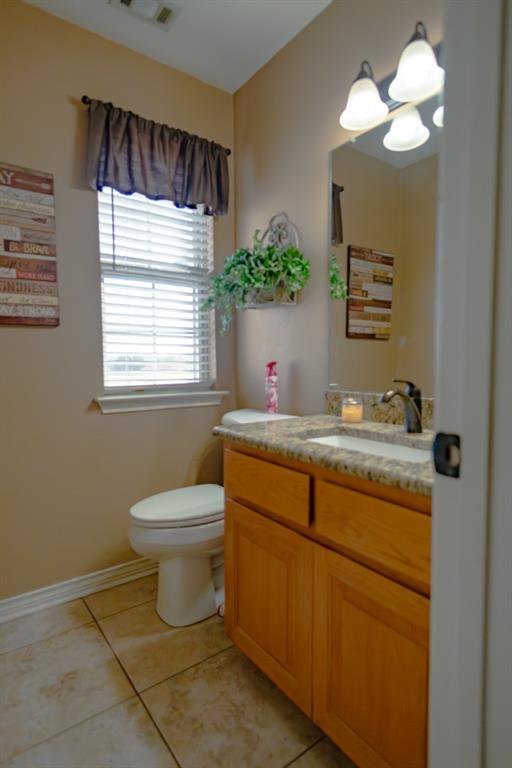 733 Ridgeview Drive Sherman, TX 75090 - Photo 15 of 40 a bathroom with a granite countertop sink toilet a mirror and a window