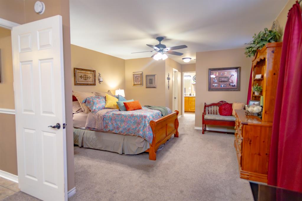 733 Ridgeview Drive Sherman, TX 75090 - Photo 21 of 40 a bedroom with a bed and a chandelier