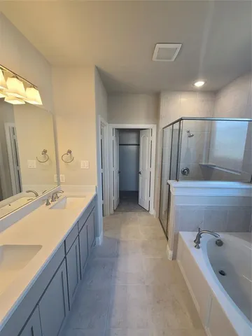 a bathroom with a tub sink and mirror