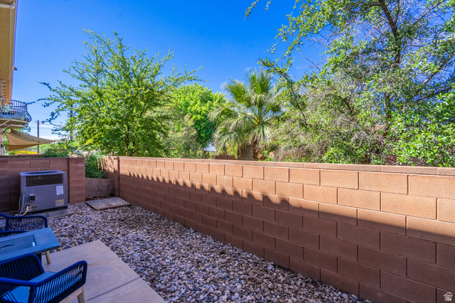 700 North Main Street, Unit F3 Washington, UT 84780 - Photo 26 of 34 Private outdoor space featuring a block wall surround, gravel ground cover, and mature green trees