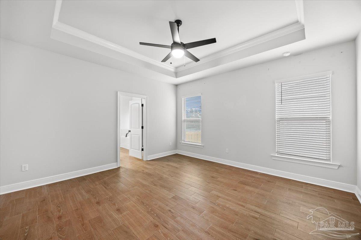 5362 Adeline Circle Pace, FL 32571 - Photo 20 of 40 an empty room with wooden floor ceiling fan and windows