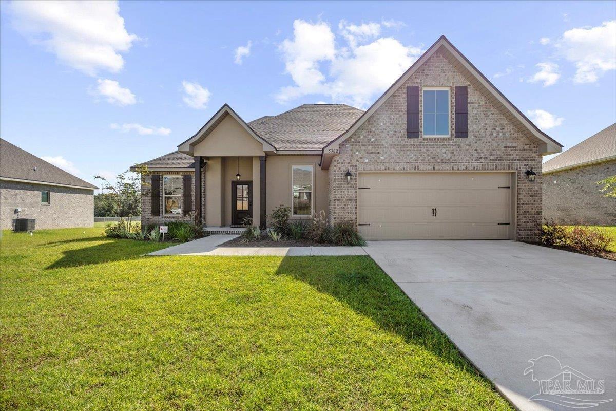 5362 Adeline Circle Pace, FL 32571 - Photo 2 of 40 a front view of a house with yard and a garage