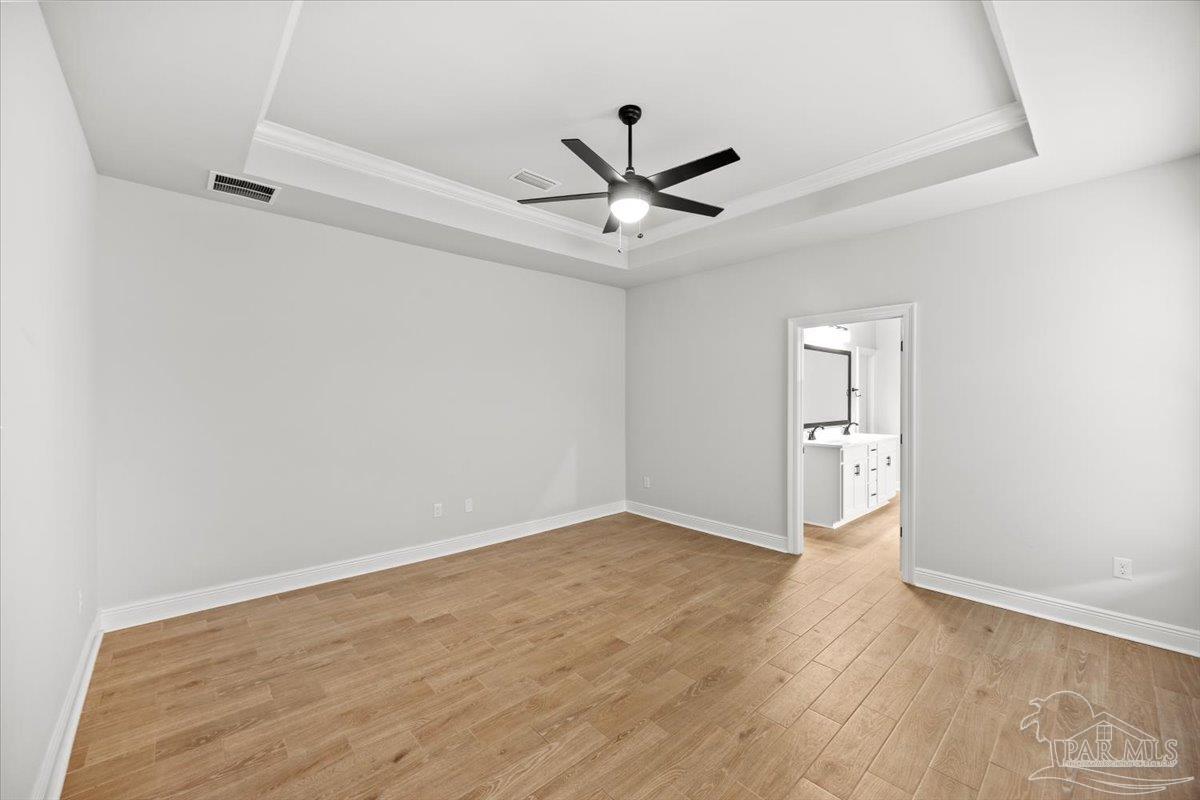 5362 Adeline Circle Pace, FL 32571 - Photo 22 of 40 an empty room with wooden floor a ceiling fan and windows
