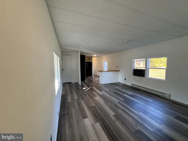 a view of a room with wooden floor and window