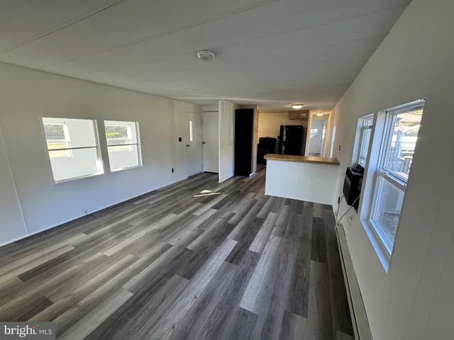 a view of empty room with wooden floor and window
