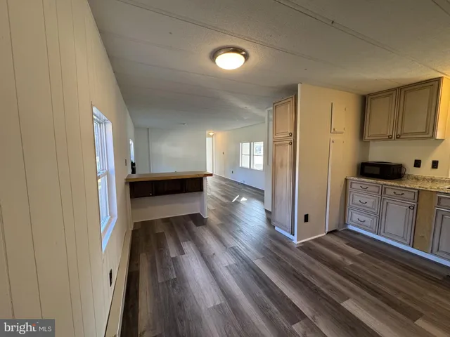 a view of a kitchen with wooden floor and electronic appliances