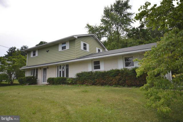 a front view of house with yard and trees in the background