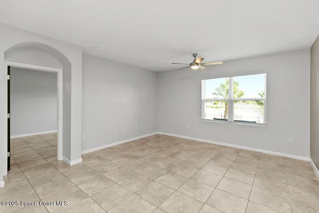 an empty room with windows and ceiling fan