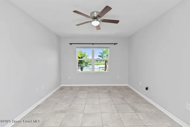 an empty room with a window and a ceiling fan