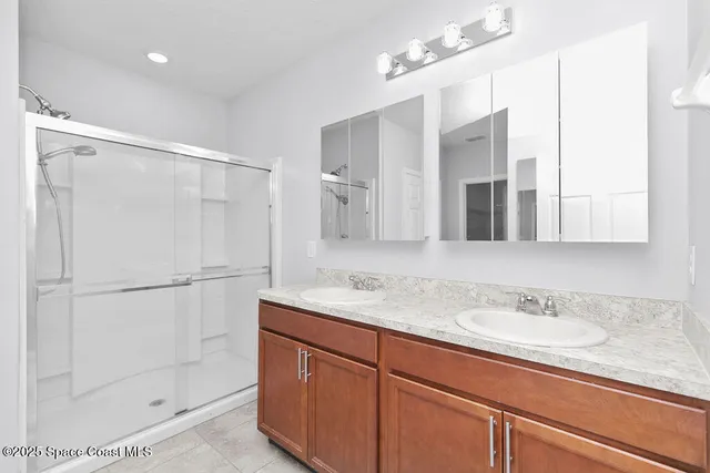 a bathroom with a granite countertop sink mirror and a shower