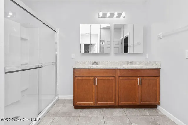 a bathroom with a granite countertop sink a mirror and a shower