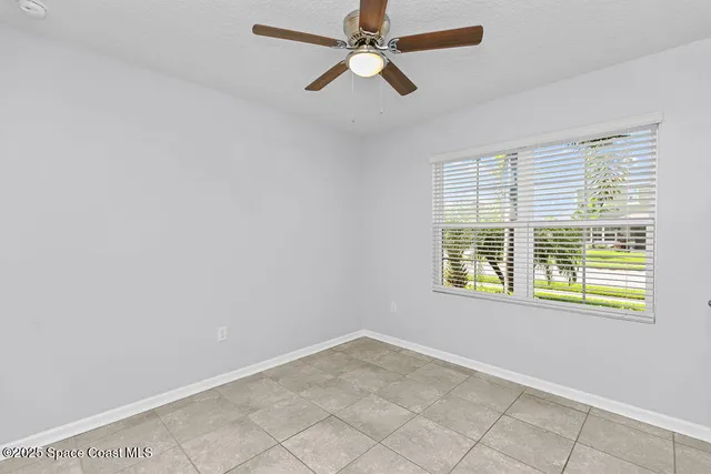 an empty room with a window and a fan
