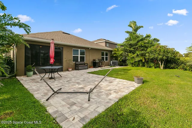 a view of house with a yard and potted plants