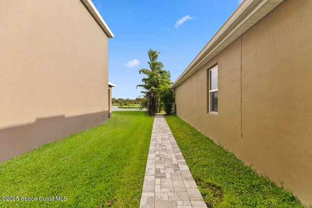 a front view of a house with a yard and potted plants