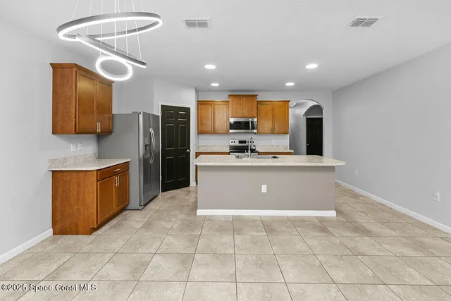 a kitchen with stainless steel appliances a refrigerator sink and microwave