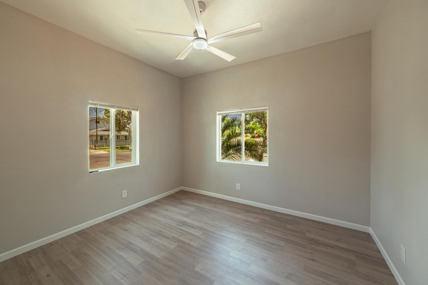 2320 K Street Merced, CA 95340 - Photo 12 of 25 an empty room with wooden floor and windows