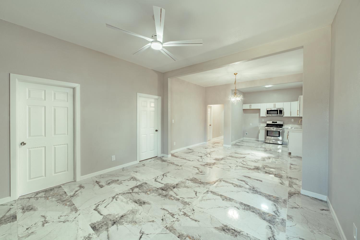 2320 K Street Merced, CA 95340 - Photo 15 of 25 a view of a bedroom with a bed and a chandelier fan