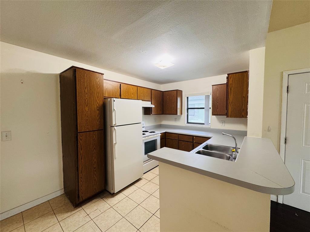 4090 North Pine Island Road, Unit 301 Sunrise, FL 33351 - Photo 8 of 16 a kitchen with stainless steel appliances a refrigerator and a sink