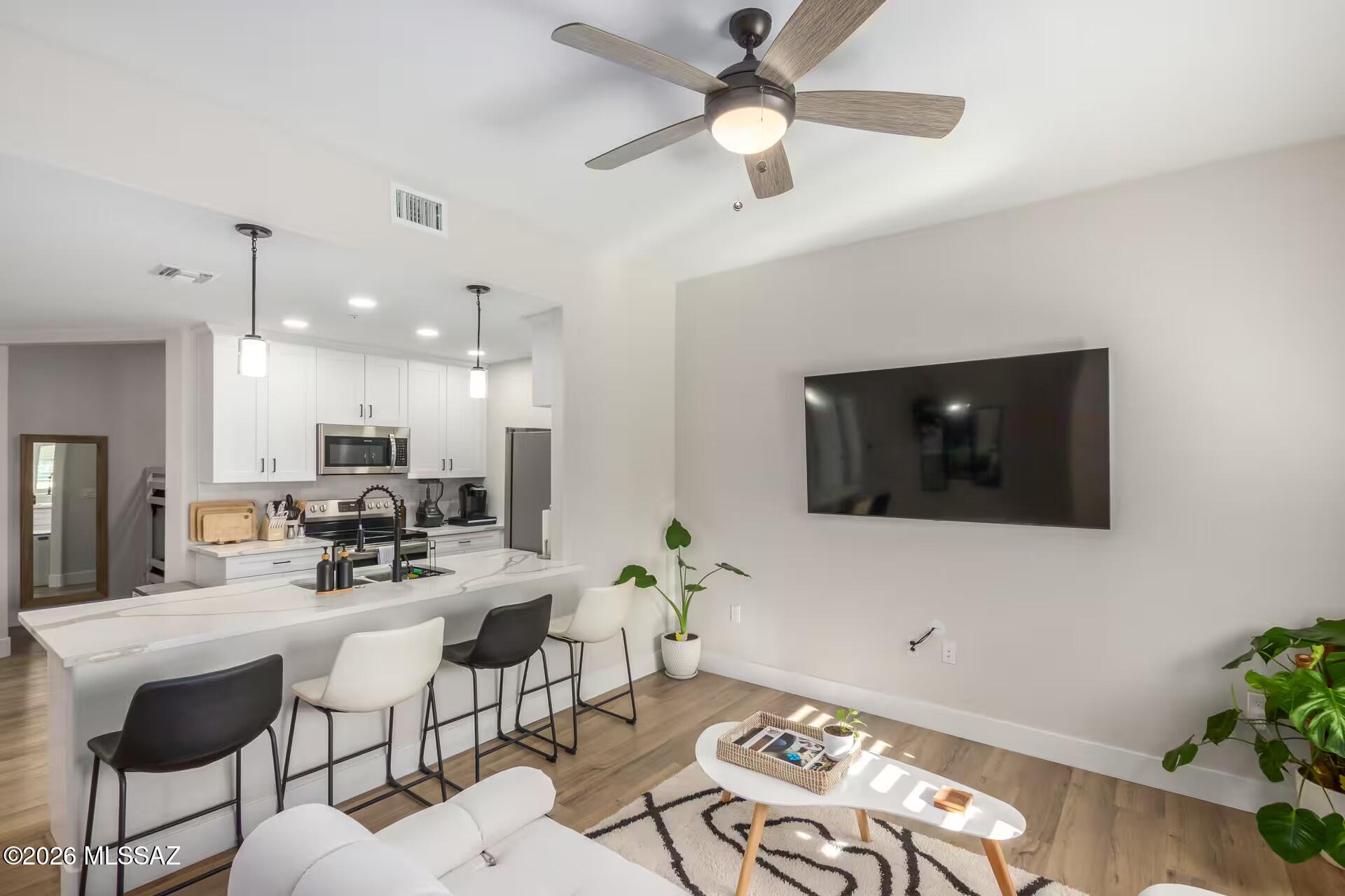 2036 East River Road, Unit 104 Tucson, AZ 85718 - Photo 3 of 23 a living room with furniture and a flat screen tv